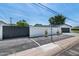 View of the front gate, a section of the white brick fence, and the garage that offer an enclosed space at 3102 E Mariposa St, Phoenix, AZ 85016