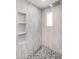 Contemporary shower with patterned gray tile, stylish hexagon floor, built-in storage and rain shower fixture at 3102 E Mariposa St, Phoenix, AZ 85016