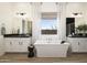 Bright bathroom featuring a modern soaking tub and dual vanities, complemented by wood-look tile flooring at 3332 W Sunstone Dr, San Tan Valley, AZ 85144