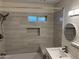 Modern bathroom with gray, subway-style tile, shower with built-in storage and window at 344 E Aepli Dr, Tempe, AZ 85282