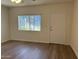 Inviting bedroom featuring wood-look floors, natural light from a window, and convenient outdoor access at 344 E Aepli Dr, Tempe, AZ 85282