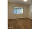 This is a well-lit bedroom with wood-look floors and a large window at 344 E Aepli Dr, Tempe, AZ 85282