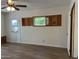 This bedroom features wood-look floors, a ceiling fan, and a door to the outside, with natural light from the window at 344 E Aepli Dr, Tempe, AZ 85282