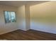 This is a well-lit bedroom with wood-look floors and a large window at 344 E Aepli Dr, Tempe, AZ 85282