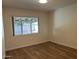 This is a well-lit bedroom with wood-look floors and a large window at 344 E Aepli Dr, Tempe, AZ 85282