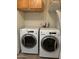 Bright laundry area with white washer and dryer units, complemented by functional overhead storage cabinets at 344 E Aepli Dr, Tempe, AZ 85282