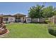 Expansive backyard with lush green lawn, large covered carport, shed and landscaped garden beds at 3802 W Kelton Ln, Phoenix, AZ 85053