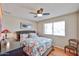 Comfortable bedroom featuring wood floors, ceiling fan, and natural light from a window at 3802 W Kelton Ln, Phoenix, AZ 85053