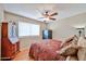 A cozy bedroom showcasing a ceiling fan, window, and a safe for security at 3802 W Kelton Ln, Phoenix, AZ 85053