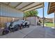 Covered carport area with scooters, covered car, shed and outdoor seating, offering convenient parking at 3802 W Kelton Ln, Phoenix, AZ 85053