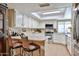 Bright kitchen featuring white cabinetry, tile floors and an eat-in counter at 3802 W Kelton Ln, Phoenix, AZ 85053