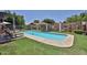 Backyard pool with lounge chairs, landscaping, and a decorative block wall, creating a relaxing outdoor space at 3802 W Kelton Ln, Phoenix, AZ 85053