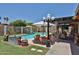 Inviting backyard oasis with a sparkling pool, lounge chairs, shade umbrellas, and a covered patio for outdoor enjoyment at 3802 W Kelton Ln, Phoenix, AZ 85053