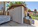 A white-painted shed adds extra storage space on the property, accompanied by a covered car and a decorative outdoor sofa at 3802 W Kelton Ln, Phoenix, AZ 85053