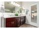 Bathroom with a dual sink vanity, wooden cabinets, and a bright interior, enhanced by natural light at 4137 E Stanford Ave, Gilbert, AZ 85234