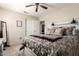 Comfortable bedroom with a decorative headboard, patterned bedding, ceiling fan, and mirrored accent decor at 4137 E Stanford Ave, Gilbert, AZ 85234