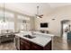 Kitchen with stainless steel appliances, dark cabinets, and an island that seamlessly connects to the dining and living spaces at 4137 E Stanford Ave, Gilbert, AZ 85234