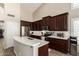 Kitchen showcasing dark cabinets, stainless steel appliances, and a white countertop island with bar seating at 4137 E Stanford Ave, Gilbert, AZ 85234
