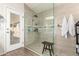 Modern bathroom features a glass-enclosed shower with tiled walls, a rain shower head, and a convenient shower bench at 4137 E Stanford Ave, Gilbert, AZ 85234