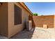 Exterior view of the air conditioning unit of the property with desert landscaping and privacy fence at 42551 W Anne Ln, Maricopa, AZ 85138