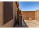 Exterior view of the air conditioning unit of the property with desert landscaping and privacy fence at 42551 W Anne Ln, Maricopa, AZ 85138