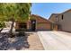 Charming single-story home with a well-maintained front yard, mature tree, and attached two-car garage at 42551 W Anne Ln, Maricopa, AZ 85138