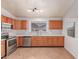Kitchen features stainless steel appliances, wood cabinets, and tile flooring at 42551 W Anne Ln, Maricopa, AZ 85138