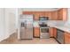 Kitchen with stainless steel appliances, light wood cabinets, and tile flooring at 42551 W Anne Ln, Maricopa, AZ 85138