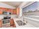 Bright kitchen with stainless steel appliances, wood cabinets, and a window over the sink at 42551 W Anne Ln, Maricopa, AZ 85138