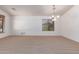 Bright, open living room featuring neutral carpet, bright white walls, and ample natural light from the windows at 42551 W Anne Ln, Maricopa, AZ 85138