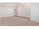 Spacious living room featuring neutral carpet, bright white walls, and an arched entry way with an elegant chandelier at 42551 W Anne Ln, Maricopa, AZ 85138