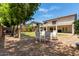 Spacious backyard featuring a well-maintained lawn, gravel, patio, and cozy outdoor seating area at 44517 W Copper Trl, Maricopa, AZ 85139