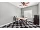 Bedroom or office features a ceiling fan and distinctive checkerboard-patterned carpet at 44517 W Copper Trl, Maricopa, AZ 85139