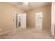 Bedroom featuring three entry doorways, carpet flooring, neutral walls, and a ceiling fan at 44517 W Copper Trl, Maricopa, AZ 85139