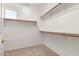 Walk-in closet with carpet flooring, a window, and shelves with rods for ample storage at 44517 W Copper Trl, Maricopa, AZ 85139
