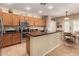 A bright kitchen with granite counters, stainless appliances, a breakfast bar, and a dining area at 44517 W Copper Trl, Maricopa, AZ 85139