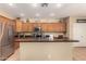 An open kitchen features an island, stainless steel appliances, and plenty of counter space at 44517 W Copper Trl, Maricopa, AZ 85139