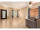 Bright living room with tile flooring, ceiling fan, and decorative front door offering a welcoming space at 44517 W Copper Trl, Maricopa, AZ 85139