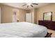 A spacious main bedroom featuring a large dark wood bed frame and carpeted floors at 44517 W Copper Trl, Maricopa, AZ 85139