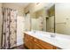 Bright bathroom with a double sink vanity, large mirror and shower tub combo with decorative shower curtain at 45391 W Portabello Rd, Maricopa, AZ 85139