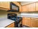 Close-up of the kitchen stove and microwave with wood cabinetry and countertops at 45391 W Portabello Rd, Maricopa, AZ 85139