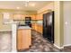Kitchen with oak cabinets, black appliances, and a convenient breakfast bar at 45391 W Portabello Rd, Maricopa, AZ 85139