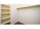 Bright closet with built-in shelving, providing organized storage solutions, complemented by carpeted flooring at 45391 W Portabello Rd, Maricopa, AZ 85139