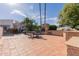 Beautiful backyard featuring a tile patio, outdoor kitchen with fireplace, mature trees, and spiral staircase at 5237 N 106Th Ave, Glendale, AZ 85307