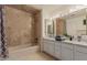 Bathroom featuring double sinks, shower and bath combo, and vanity with decorative mirror and lights at 5237 N 106Th Ave, Glendale, AZ 85307