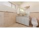 Well-lit bathroom with marble countertops, tiled walls, and toilet at 5237 N 106Th Ave, Glendale, AZ 85307