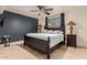 Bedroom featuring a dark blue accent wall and a decorative wrought iron bed frame with travertine flooring at 5237 N 106Th Ave, Glendale, AZ 85307