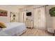 Bright bedroom featuring a queen bed, wood floors, a wall-mounted TV and ample natural light at 5237 N 106Th Ave, Glendale, AZ 85307