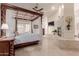 Luxurious bedroom features a four-poster bed, tile floors, and a view of the fireplace at 5237 N 106Th Ave, Glendale, AZ 85307