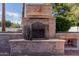 Close-up of the backyard fireplace built with stone and decorated with a sun, providing a cozy outdoor focal point at 5237 N 106Th Ave, Glendale, AZ 85307